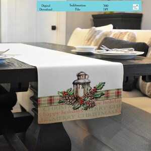 May include: A white table runner with a red and green plaid border. The runner features a vintage lantern with pine cones and holly. The text "CHRISTMAS happy holidays MERRY CHRISTMAS happy holidays MERRY CHRISTMAS ha" is printed on the runner.