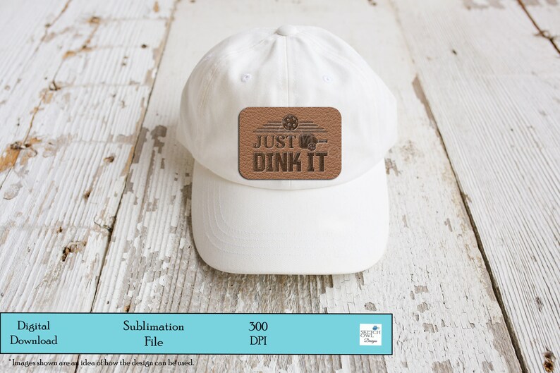 K&ouml;nnte beinhalten: Wei&szlig;e Baseballkappe mit einem braunen Lederpatch, auf dem "JUST DINK IT" steht, mit einer Grafik eines Basketballkorbs und eines Balls.
