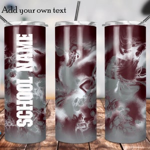 May include: A stainless steel tumbler with a maroon and silver marble design. The tumbler has a white inscription that says "SCHOOL NAME".