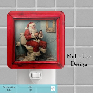 May include: A red framed night light with a picture of Santa Claus sitting on a toilet and looking at a phone. The text "Multi-Use Design" is below the picture.