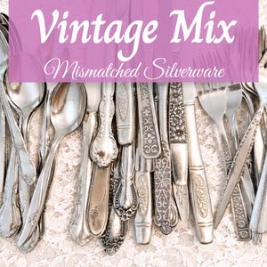 May include: A collection of mismatched silver-toned metal flatware including various spoons, forks, and knives with ornate embossed handle designs. The text "Vintage Mix Mismatched Silverware" is overlaid across the top of the utensils.