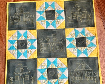 Tapiz de pared con motivos de cabañas y colchas