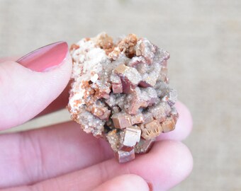 Stunning red Vanadinite coated in druzy calcite crystals on pale pink barite. Bright red cluster from Mibladen, Morocco.