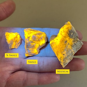 Puede incluir: Tres piedras fluorescentes amarillas de diferentes tamaños, etiquetadas como "X-Small", "Small" y "Medium".