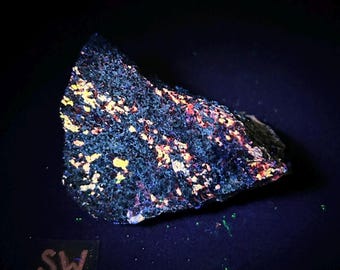 Fluorescent Wollastonite, Hydrozincite, and Franklinite. Yellow shortwave SW fluorescence. From Sterling Hill Mine, NJ.