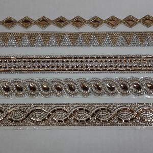 May include: Five different trims of gold and silver rhinestone embellishments. The trims are arranged in a row from top to bottom. The top trim is a diamond pattern, the second trim is a triangle pattern, the third trim is a square pattern, the fourth trim is a teardrop pattern, and the fifth trim is a wavy pattern.