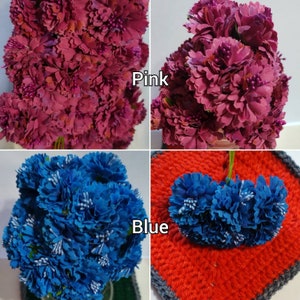 May include: Two bunches of artificial flowers, one pink and one blue. The pink flowers are arranged in a bouquet, while the blue flowers are arranged in a circle. The flowers are all made of fabric and have a realistic appearance.