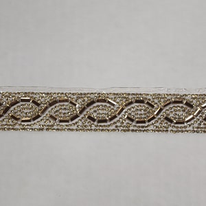 May include: Gold and clear beaded trim with a wavy pattern.