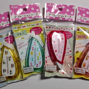 May include: Four colorful correction tape dispensers with different designs. Each dispenser has a clear plastic body with a decorative tape inside. The designs include pandas, hearts, ribbons, and a cartoon character. The tape is 6mm wide and 6m long.