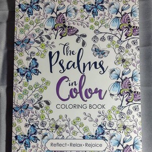 May include: A coloring book titled "The Psalms in Color" with a white background and a floral design featuring butterflies. The text "Reflect. Relax. Rejoice" is printed at the bottom of the cover.