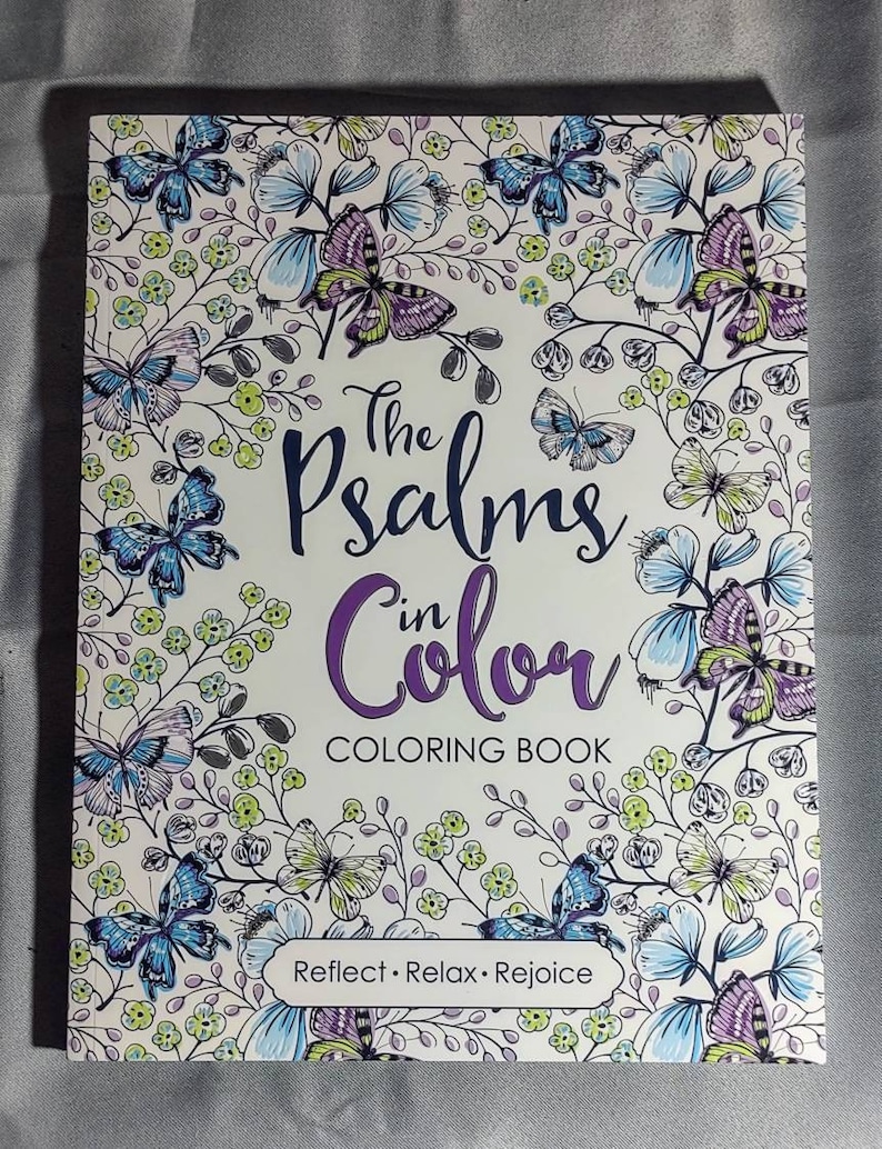 May include: A coloring book titled "The Psalms in Color" with a white background and a floral design featuring butterflies. The text "Reflect. Relax. Rejoice" is printed at the bottom of the cover.