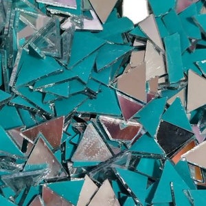 May include: A pile of teal-colored triangular mirror tiles. The tiles are made of glass and have a reflective surface. They are perfect for crafting and DIY projects.