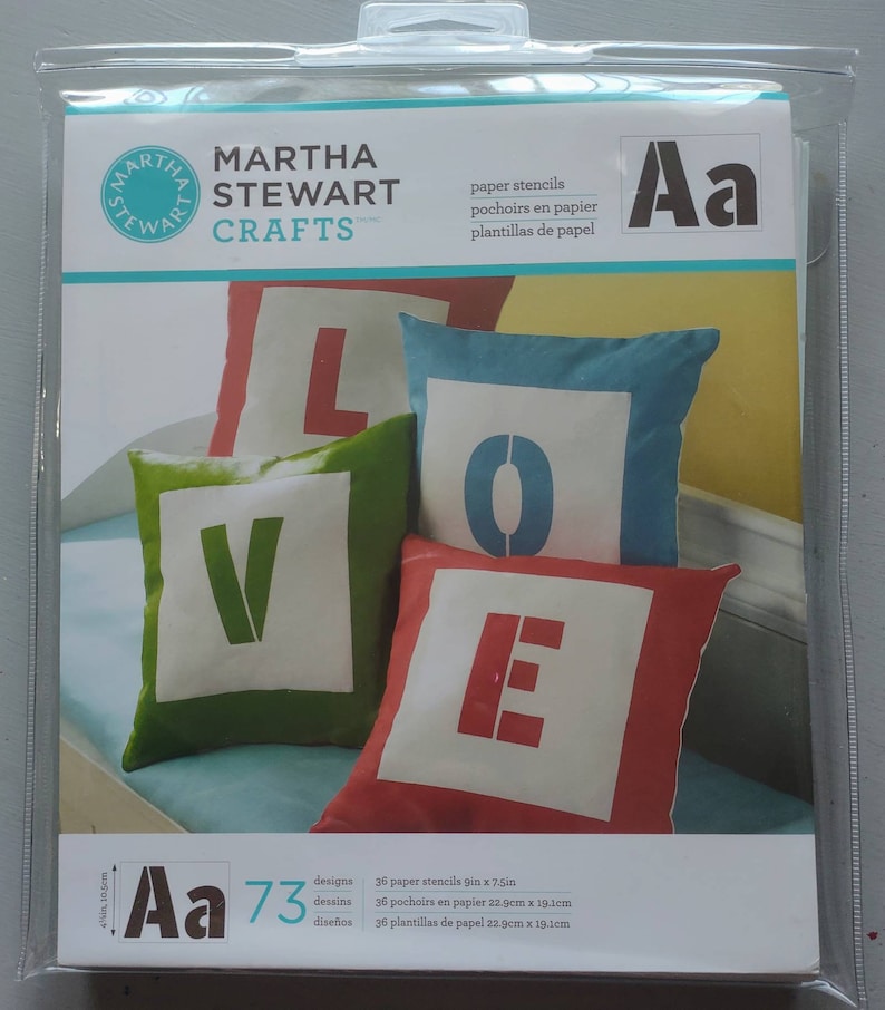 Puede incluir: Un paquete de 36 plantillas de papel para manualidades. Las plantillas miden 19,1 cm x 19,1 cm y presentan letras del alfabeto. El paquete est&aacute; etiquetado como "Martha Stewart Crafts" e incluye el texto "Aa 73 dise&ntilde;os".