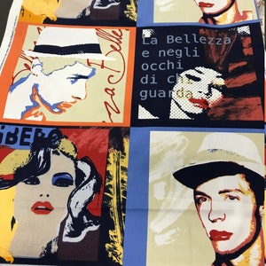 May include: A colorful fabric with a repeating pattern of four portraits. Each portrait is of a person with a different hairstyle and expression. The fabric has a black, white, red, blue, and yellow color scheme. The text "La Bellezza e negli occhi di chi guarda" is visible in the center of the fabric.
