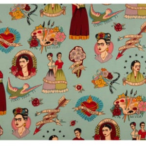 May include: A light blue fabric featuring a repeating pattern of Frida Kahlo portraits, hearts, arrows, paint palettes, and floral elements. The design includes text in Spanish. The overall aesthetic is reminiscent of tattoo art.