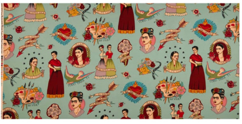 May include: A light blue fabric featuring a repeating pattern of Frida Kahlo portraits, hearts, arrows, paint palettes, and floral elements. The design includes text in Spanish. The overall aesthetic is reminiscent of tattoo art.