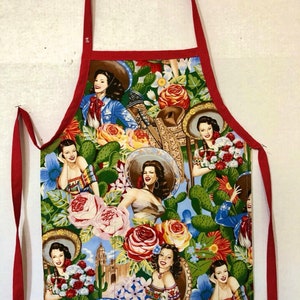 May include: Red and white apron with a colorful floral print featuring women in sombreros and cacti.