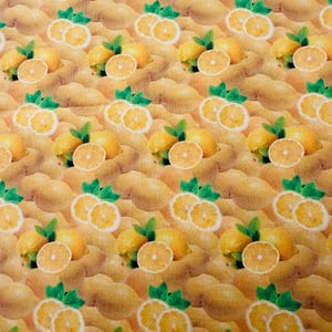 Peut inclure: Un motif répétitif de citrons jaunes et de feuilles vertes sur un fond beige clair. Le design présente des citrons entiers et des rondelles de citron, chacun accompagné de petites feuilles vertes, disposés en une grille dense et uniforme.