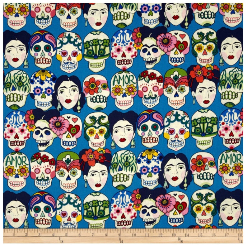 May include: A blue fabric with a repeating pattern of colorful sugar skulls with floral designs and the word "AMOR" on some of the skulls. The skulls are surrounded by flowers and hearts.