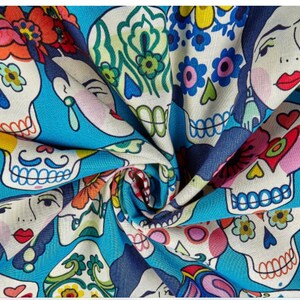 May include: A blue fabric with a repeating pattern of colorful sugar skulls with floral designs. The skulls have black eyes and mouths, and some have mustaches. The fabric is perfect for crafting projects, like making masks, bags, or clothing.
