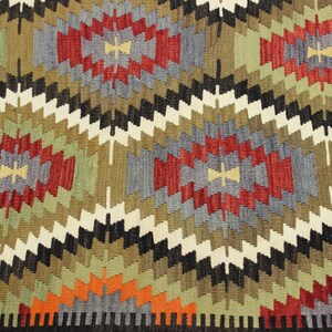May include: A colorful rug with a geometric pattern in shades of red, green, blue, black, and white. The rug has a traditional design with repeating diamond shapes.