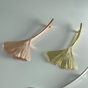 May include: Three ginkgo leaf hair clips in rose gold, gold, and silver.