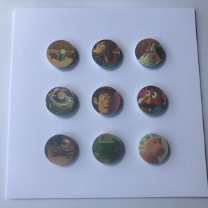 Può includere: Nove bottoni rotondi con personaggi di Toy Story. I bottoni raffigurano Woody, Buzz Lightyear, Jessie, Mr. Potato Head, Rex, Slinky Dog, Hamm e l'alieno verde.