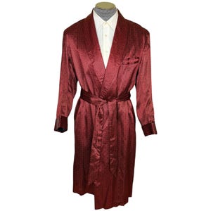 Puede incluir: Una bata roja con estampado y cuello blanco y una cinta a juego.