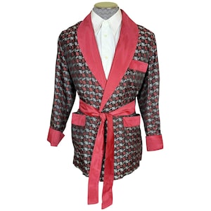 Może przedstawiać: Szlafrok w czerwono-czarny wzór z czerwonym satynowym kołnierzem i paskiem. Szlafrok ma kołnierz szalowy i długie rękawy.