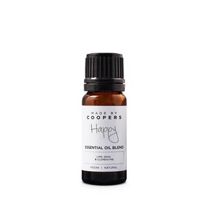 Può includere: Una piccola bottiglia di vetro marrone con tappo nero. L'etichetta recita "Made by Coopers" e "Happy Essential Oil Blend". La miscela include lime, basilico e clementina. La bottiglia è etichettata come vegana e naturale.