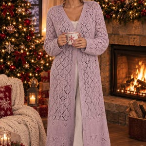 Peut inclure: Un long cardigan violet clair ouvert sur le devant, doté d'un motif en tricot complexe en forme de losange sur tout le corps et les manches. Le vêtement présente une encolure en V, des manches longues à poignets côtelés et une fermeture boutonnée.