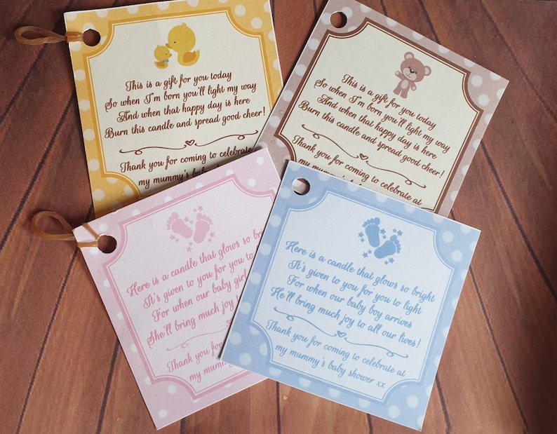 Puede incluir: Cuatro cajas de regalo con fondo blanco y lunares de colores. Cada caja tiene un color y un dise&ntilde;o diferente. Las cajas tienen un peque&ntilde;o agujero en la parte superior y una cinta atada. Las cajas tienen un poema impreso sobre ellas sobre un baby shower.