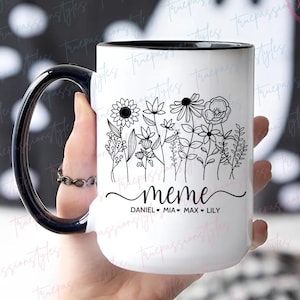 May include: White ceramic mug with a black rim and handle. The mug has a black and white floral design with the word "meme" and the names "Daniel, Mia, Max, Lily" written below.