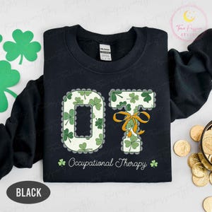 May include: Black sweatshirt with the letters "OT" in a shamrock design, with the words "Occupational Therapy" below. The "T" is adorned with an orange bow. The sweatshirt is a Gildan brand.