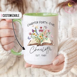 May include: White ceramic mug with a green handle and interior. The mug features the text "CHAPTER FORTY-FIVE" and "Charlotte EST. 1981" with a floral and butterfly design. The word "CUSTOMIZABLE" is in a white oval.