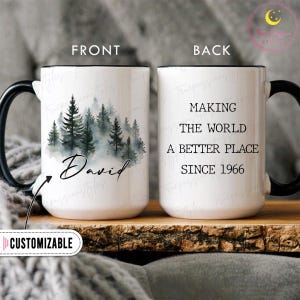 Può includere: Tazza in ceramica bianca con manico e bordo neri. La parte anteriore presenta una scena di foresta ad acquerello e il nome "David". Il retro recita "MAKING THE WORLD A BETTER PLACE SINCE 1966". La tazza è personalizzabile.