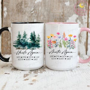 Può includere: Due tazze in ceramica bianca. Una ha un manico nero e presenta una scena di foresta ad acquerello con il testo "Uncle Again" e nomi. L'altra ha un manico rosa e presenta un disegno floreale con il testo "Auntie Again" e nomi.