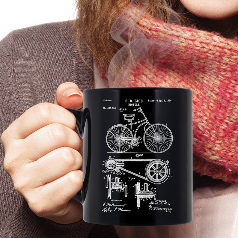 May include: Black coffee mug with a white image of a bicycle patent drawing. The patent is for a C.D. Rice Bicycle, patented April 8, 1900. The patent number is 498,300.