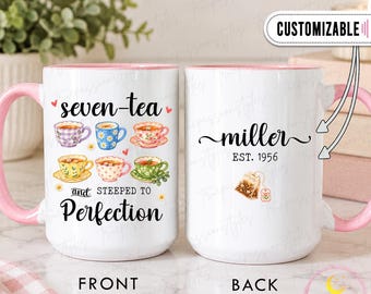 Puede incluir: Dos tazas de cerámica blanca con asas e interiores rosas. El frente presenta seis ilustraciones de tazas de té coloridas con el texto seven-tea y STEEPED TO Perfection. El reverso muestra el nombre miller, EST. 1956 y un gráfico de bolsita de té.