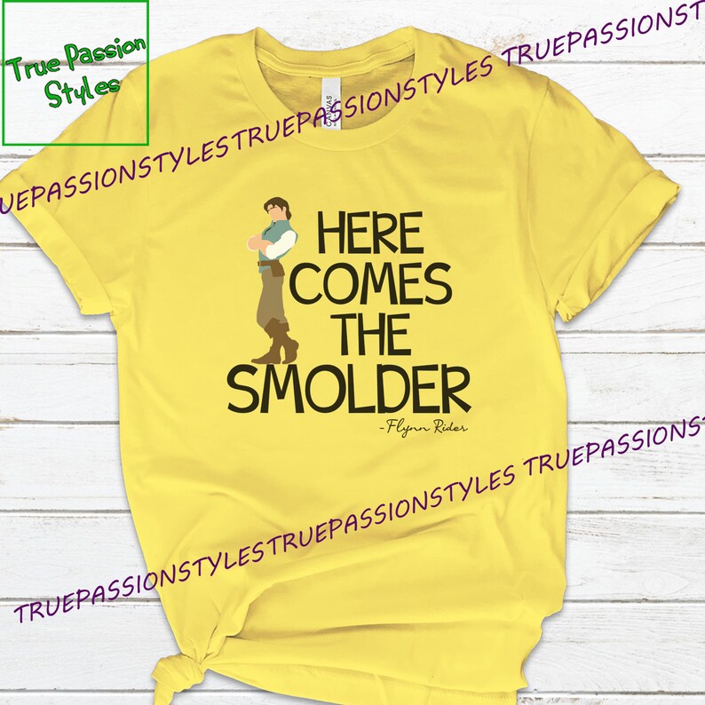 May include: Yellow t-shirt with a cartoon illustration of Flynn Rider from the movie Tangled. The text "Here comes the Smolder - Flynn Rider" is printed on the shirt.