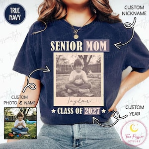 Może przedstawiać: Granatowa koszulka z napisem "SENIOR MOM" nad czarno-białym zdjęciem. Na zdjęciu dziecko i imię "Taylor" z napisem "CLASS OF 2027" poniżej. Koszulka ma okrągły dekolt.
