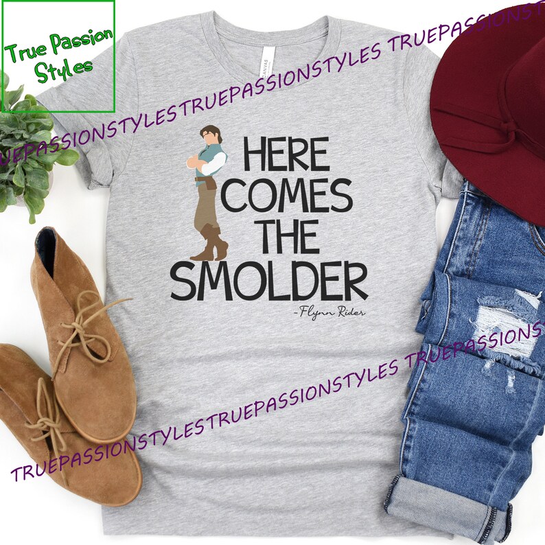 May include: A gray t-shirt with a graphic of a cartoon man with the text "Here comes the Smolder - Flynn Rider".