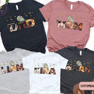 May include: A collection of customizable t-shirts in various colors, featuring the words "DAD", "MOM", "LIAM", "KIRA", and "ISAIAH". Each word is designed with a unique Star Wars-themed graphic. The shirts are perfect for family matching.
