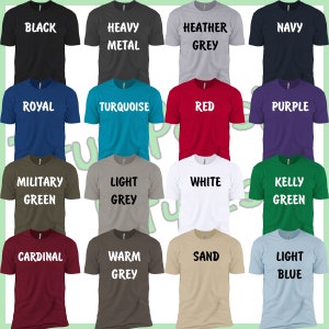 May include: A collage of 16 t-shirts in various colors, each with a different color and text. The colors include black, white, red, blue, green, grey, purple, turquoise, sand, and light blue. The text includes "Black", "Heavy Metal", "Heather Grey", "Navy", "Royal", "Turquoise", "Red", "Purple", "Military Green", "Light Grey", "White", "Kelly Green", "Cardinal", "Warm Grey", "Sand", and "Light Blue".