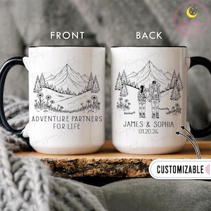 Pode incluir: Caneca de cerâmica branca com alça e borda pretas. A frente apresenta uma ilustração de paisagem montanhosa com o texto "ADVENTURE PARTNERS FOR LIFE". A parte de trás mostra um casal caminhando com os nomes "JAMES & SOPHIA" e uma data.