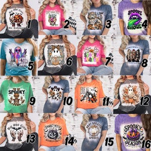 May include: Collection of Halloween-themed graphic t-shirts. Designs include ghosts, pumpkins, and spooky phrases like "Spooky Ghoul" and "Bat Shit Crazy." Shirts are in various colors with a bleached or tie-dye effect.