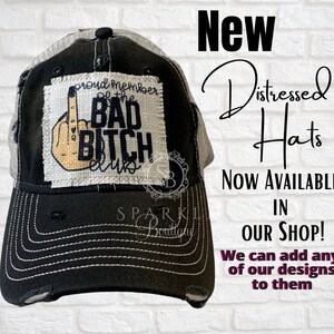 Puede incluir: Un gorro de camionero negro y blanco desgastado con un parche blanco que dice "Proud Member of the Bad Bitch Club" con un emoji de dedo medio. El gorro es nuevo y est&aacute; disponible en la tienda.