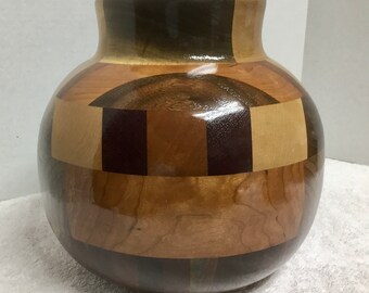 This is a segmented Bowl, woods include, padauk, Black Walnut. Maple some Mesquite. It is 8 1/2” h x 9“ w
