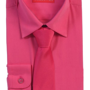 May include: A pink long-sleeve dress shirt with a matching pink tie. The shirt has a button-down collar and two buttons on the cuffs. The label on the shirt reads "AFT COLLECTION".