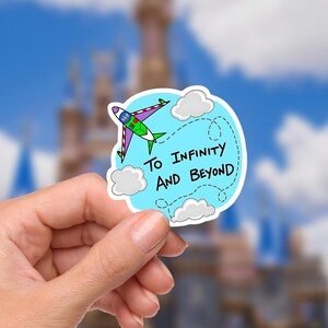 Op de afbeelding: Een sticker met een cartoonvliegtuig met groene, paarse en witte accenten, vliegend door een lichtblauwe lucht met witte wolken. De tekst "To Infinity and Beyond" staat op de sticker.